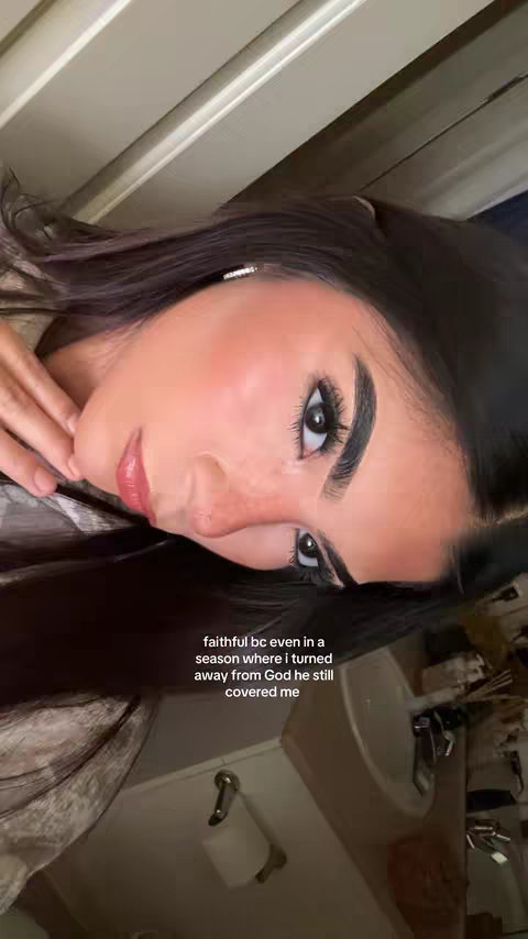 The cover image features a young woman tilted slightly to the left, her face filling most of the frame. She has dark hair and is wearing makeup, with visible eyeliner and mascara. The background is a blurred interior, with hints of a sink and other bathroom fixtures. The text overlayed reads:  "faithful bc even in a season where i turned away from God he still covered me."