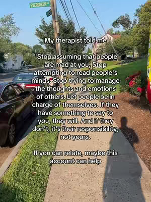 A vertical video shot taken on a sidewalk, showing a sidewalk, a street and buildings and trees in the background. Text is overlaid onto the image. The primary colors are green, brown, and gray, setting a calm, naturalistic tone. The camera is positioned at a low angle, looking up towards the sky. The road and pavement fill the lower third of the frame.