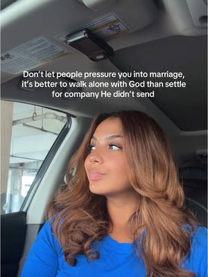 A woman with brown hair sits in the driver's seat of a car, looking off to the side with a thoughtful expression. The text overlay on the image advises against rushing into marriage to please people.