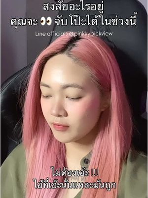 A woman with pink hair looks down with her eyes closed. The top half of the image has overlaid white text in Thai. The woman is wearing a green shirt and is seated in an office-style chair.