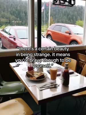 The image shows the inside of a diner with a table set for a meal. Through the window, the exterior reveals an overcast day. The foreground table is occupied. On the table there are plates, silverware, a bottle of sauce, and juice glasses. A quote appears in a black font. The quote is set against the background of a diner.