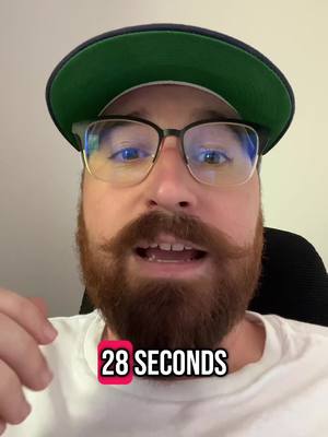 A selfie-style shot featuring a man with a beard, glasses, and a baseball cap. The man's face is the main focus, framed closely, with a hook text overlay that provides the video length. The background appears to be a plain wall.
