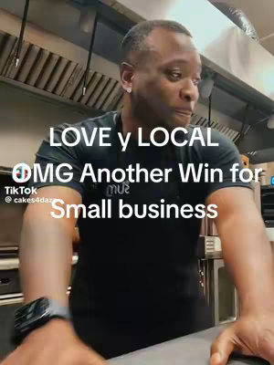 A man in a black t-shirt is standing in what appears to be a kitchen or food prep area. The image is slightly out of focus, causing some blurring. Text overlays are placed on the image.