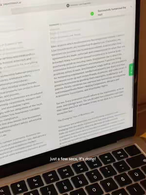 A laptop displaying text on the screen, with a keyboard in the foreground showing the letters, and a green checkmark in the top right corner.