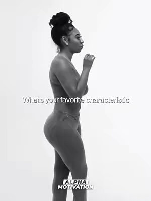 A black and white photo shows a woman standing in profile against a bright white background. She is wearing a top and pants that blend into each other in a solid color. Her hair is styled in a high bun and she is looking away from the camera. Text overlayed on the image reads, 'Whats your favorite characteristic'. At the bottom of the image is a logo that says 'ALPHA MOTIVATION'.