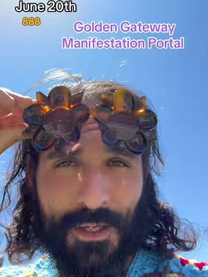 A man wearing flower-shaped sunglasses in front of a bright blue sky, the image prominently displays text overlays with information about an event or theme, The man has a beard and is looking towards the camera. The background is a clear blue sky.
