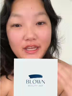 A person with dark wavy hair is centered in the frame, looking directly at the camera and speaking. They are holding a white square with the 'BLOWN BEAUTY ART' logo.