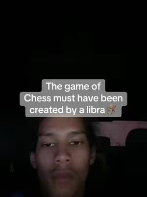 A selfie-style video with the face of a young man in the lower portion of the frame. Above his head is a text overlay in a semi-opaque shape. The background is dark, suggesting interior lighting, and perhaps a vehicle setting.