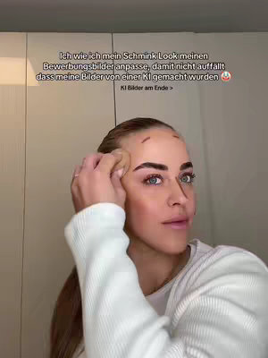 A woman is applying makeup while facing forward. Text overlays the image. The background is a light-colored wall and a cabinet.