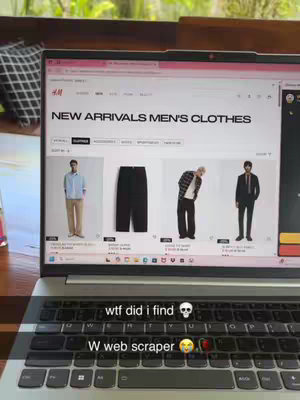 A laptop displays the H&M website, specifically the 'New Arrivals Men's Clothes' section, with images of clothing items. The bottom part of the screen shows the keyboard, with overlaid text and emojis suggesting excitement about a web scraper.