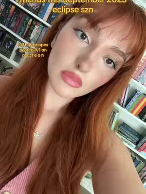 The cover image shows a fair-skinned person with long, auburn hair looking directly at the camera. The person has light makeup, including pink lipstick. There is text overlaying the image, with a background of bookshelves visible behind the person. The overall composition is a selfie style.