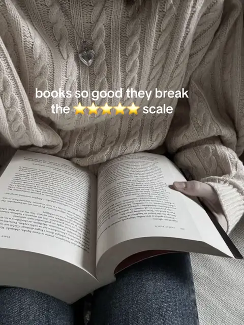 A person is sitting, wearing a cream-colored cable-knit sweater, and holding an opened book in their lap. The book's pages are visible, and the text overlay reads, "books so good they break the ⭐️⭐️⭐️⭐️⭐️ scale."