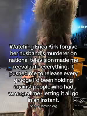 A person stands facing away from the camera with their back to a blurry background. The person appears to be wearing a long, patterned garment with a textured wig. The text overlays on the image in white.