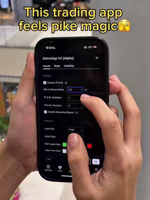 A phone held in front of the camera displays a trading app interface, while hands operate and interact with the phone. The screen features labels, buttons, and numerical inputs within the app, set against a dark interface. Above the phone, text overlays are added to the cover image.