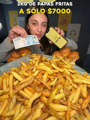 A woman holds a stack of french fries with a 10,000 peso bill and a phone showing a logo; text in the upper banner says '2KG OF FRENCH FRIES FOR ONLY $7000'. Background features more burgers and various food-related items.