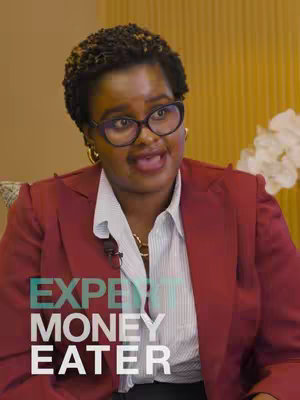 The cover image features a woman with glasses who is wearing a red blazer and white shirt sitting in front of a light-colored background. The overlayed text reads "EXPERT MONEY EATER".