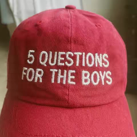 The cover image features a close-up of a red baseball cap. The cap has "5 QUESTIONS FOR THE BOYS" embroidered in white text on the front.
