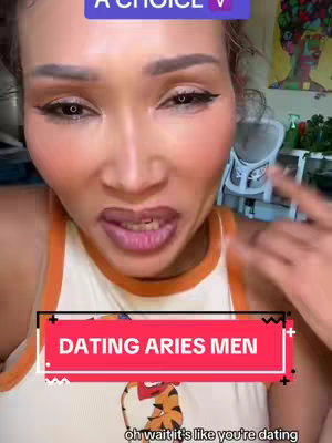 A close-up shot of a woman's face looking directly into the camera. She has full makeup and is wearing orange color top. Above her is text in a colored box.