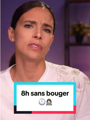 A woman with brown hair in a low ponytail is the focus of this video image. She has a concerned expression, with her brow furrowed. She wears a white shirt with an embellished shoulder. A rectangular color block with text is in the foreground, set against a blurry background.
