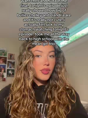 A woman with long, wavy brown hair is centered in the frame, looking directly at the camera with a neutral expression. Text overlays her image. Behind her is a light-colored wall, with hints of a window and other decorative objects.