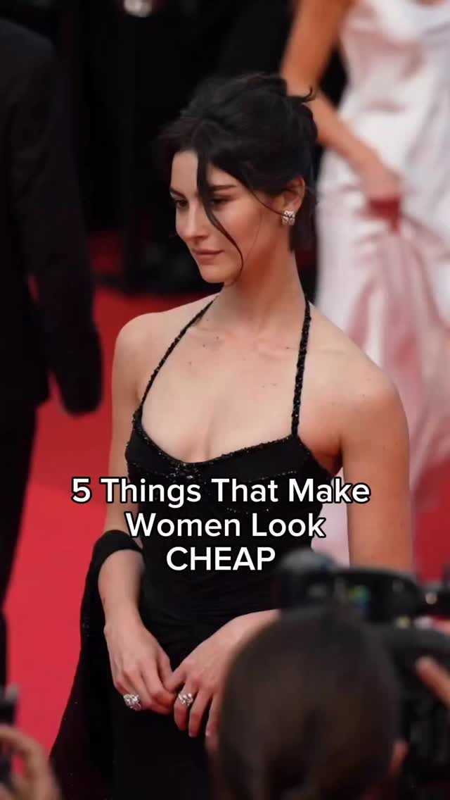 A woman in a black dress with a halter neckline stands on a red carpet, with a partially obscured background of people and photographers. The primary focus is on the woman, who appears to be posing for a photograph. Text overlayed on the image reads "5 Things That Make Women Look CHEAP".