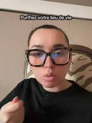 A woman with glasses is in front of the camera, with the text hook 'Purifiez votre lieu de vie' over her head. She is sitting in a chair with a distinctive patterned back.