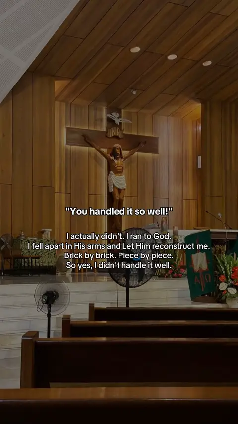 The image shows the interior of a church. A wooden cross with a crucified Jesus is in the center. Below the cross are pews.