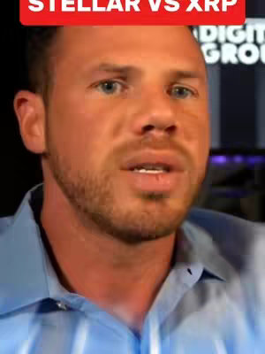 A man with light skin and short brown hair is centered in the frame. He's wearing a blue button-down shirt. Above the man is a red banner that says "STELLAR VS XRP" in white text. He appears to be speaking or reacting to something, likely discussing the difference between the two cryptocurrencies as captioned.