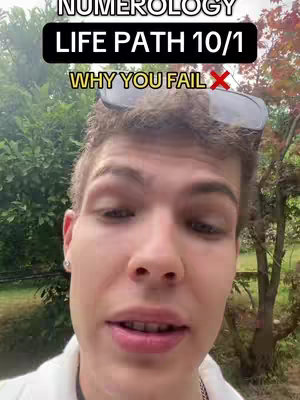The cover image features a close-up shot of a person with fair skin, positioned against a blurry natural backdrop. They are looking towards the viewer, with the top of the head and partially visible sunglasses. Text overlays in the image include the word "NUMEROLOGY" at the top in a white, all-caps font against a black rectangle, followed by "LIFE PATH 10/1" in a similar style, and the phrase "WHY YOU FAIL" with an 'X' icon, which is highlighted in a yellow hue. The overall composition uses natural colors and an outdoor setting and is focused on the face.