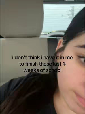 The image shows a person from the top of their chest up inside of a car. The person is partially visible. They have dark hair and a black shirt on. The background outside of the car window is gray and gloomy. Text is overlaid at the bottom of the image, written in white and centered.