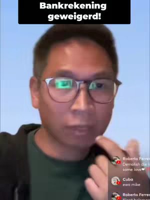 A man with glasses is looking at the camera in a medium shot. Above him is a black box containing the text 'Bankrekening geweigerd!' The background is a light blue. There are some overlaid comments to the right.