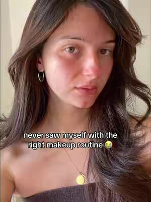 A young woman with long brown hair is gazing at the camera with a somewhat introspective expression. She has fair skin, subtle makeup, and is wearing a necklace with a gold pendant. The image has a soft, natural lighting, and a text overlay is positioned at the bottom.