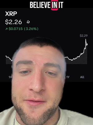 A selfie-style video cover featuring a man's face, with financial data superimposed behind him. The man, whose face is in the foreground, is fair-skinned with short brown hair and a well-groomed beard. Behind him is a chart showcasing the price of XRP. The background is black, with text overlayed at the top that reads "BELIEVE IN IT". The chart displays real-time financial information of a cryptocurrency