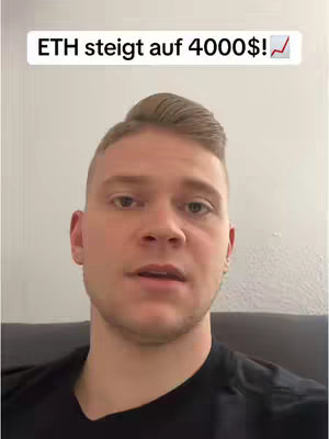 A man is centered in the frame, seen from the chest up, against a plain wall background. He is fair-skinned with short, light brown hair. Above him, a white box contains text, and a red upward-pointing graph symbol is next to it. The man is wearing a black t-shirt and looking toward the viewer expressionlessly. The lighting is somewhat soft, highlighting his features.
