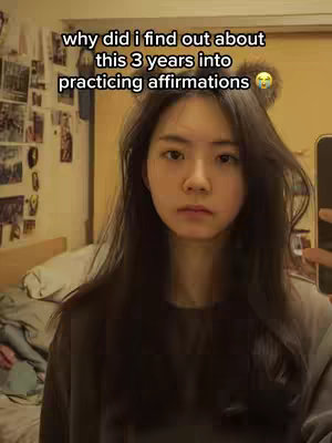 A woman with long dark hair and a gray sweatshirt looks directly into the camera with a slightly serious expression. Text overlays the image.