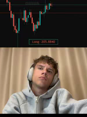 The cover image is split, with the upper portion showing a candlestick chart in green and red, and the lower half a young man with headphones, wearing a gray hoodie. The man is looking slightly up with a neutral expression. Behind him is a beige curtain.