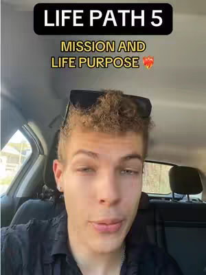 A selfie-style video cover image featuring a young man sitting in a car seat. He is looking directly at the camera. Above his head, in a black banner, is the text "LIFE PATH 5" in white letters. Below this, overlaid in yellow, are the words, "MISSION AND LIFE PURPOSE", with a heart emoji next to it.