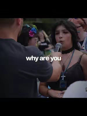 The cover image shows a woman speaking into a microphone, likely at an event. She is wearing a black outfit and a cross necklace. The text overlayed on the image reads 'why are you.' People are in the background.