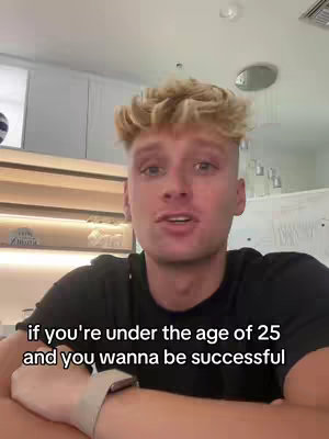 A young man with blonde, curly hair looks directly at the camera, speaking in a room with simple, modern decor. Text overlayed on the image reads: 'if you're under the age of 25 and you wanna be successful'. The shot is framed to focus on his upper body and face.