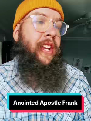 A man with glasses and a beard is speaking to the camera. He is wearing a yellow beanie and a plaid shirt. Text is displayed in a rectangle at the bottom of the image.