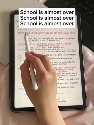 A hand holding a white stylus is pointing at the screen of a tablet. The screen displays handwritten notes. Above this is a white bar with the text "School is almost over" repeated three times. The hand that holds the pen appears to be on a bed, since the fabric is visible underneath. The overall lighting appears to be natural, suggesting sunlight.