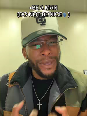 A man in glasses and a baseball cap with text overlayed. He is centered and looking at the camera with a slight smile. He has a cross necklace. The background is a plain wall, likely indoors.