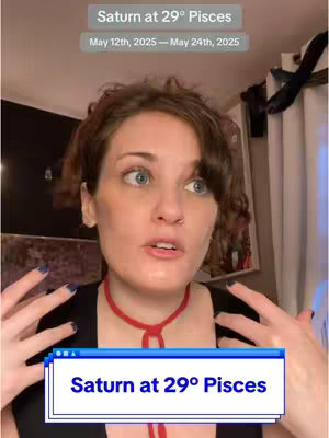 A woman with fair skin and short brown hair stands in front of a blurred background. She's wearing a black top and a red choker. Text overlays on the image read: "Saturn at 29° Pisces" and "May 12th, 2025 - May 24th, 2025".