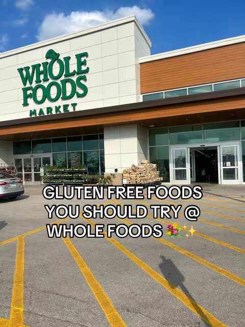 The cover image shows the facade of a Whole Foods Market store under a clear blue sky. The building is modern with a combination of off-white panels and a brown wooden facade. Large glass windows and doors are visible to the left and center, with the Whole Foods Market logo prominently displayed in green. Yellow parking lot lines are visible in the foreground, and text is overlaid at the bottom providing context to the video.