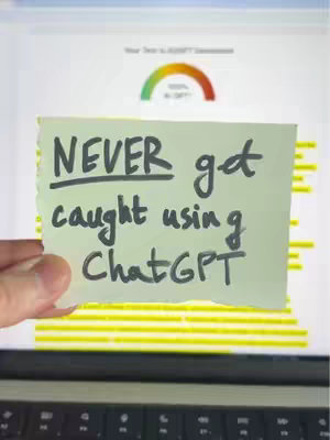 A hand holding a piece of torn paper with handwritten text in front of a laptop displaying a performance assessment. The paper is light yellow. The background screen shows a colored gauge.