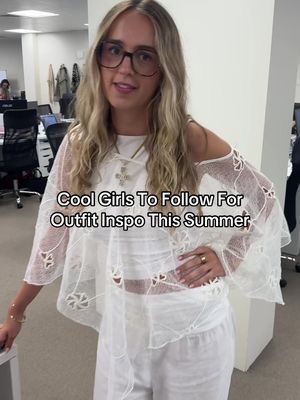 A woman with long blonde hair and large, square glasses stands in an office setting. She wears a white, open-shoulder blouse over a white outfit. Text overlayed on the image reads "Cool Girls To Follow For Outfit Inspo This Summer". The background includes office furniture and other people.