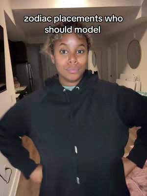 A person is standing facing the camera with a neutral expression, wearing a black hoodie. Text overlay indicates a video about zodiac placements.