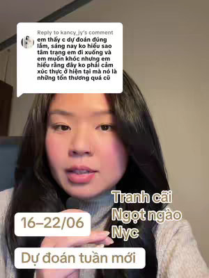 A woman with black hair and a neutral expression is centered in the shot. Text boxes with white backgrounds lay on the image and have various text. In the image's background, there is a light grey room.
