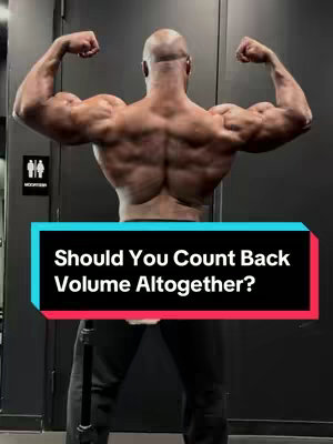 A muscular man with a bald head is seen from the back, flexing his arms to show off his back muscles. He is standing with a dark background. Text overlayed shows the title of the video.