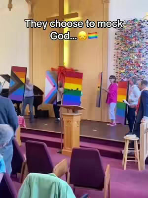 The cover image shows the interior of a church with several people standing in front of an altar. Some are holding large, colorful rectangles with rainbow and other symbolic designs. Text overlays read, "They choose to mock God..." and a rainbow flag emoji.
